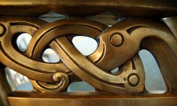The brass railings of the main staircase feature intertwined mythological creatures that form a braid pattern.