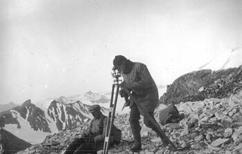 The expedition went back through the Matochkin Strait just before it refilled with drifting ice and continued their investigations along the west coast of the northern island. A small group of men climbed up a mountain to take topographic measurements from there. This picture, taken on the top of the mountain, features Olaf Holtedahl and Brynjulf Dietrichson.
