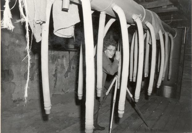 Draftsman and photographer Ingrid Lowzow hidden among the long arms of a milk pump.