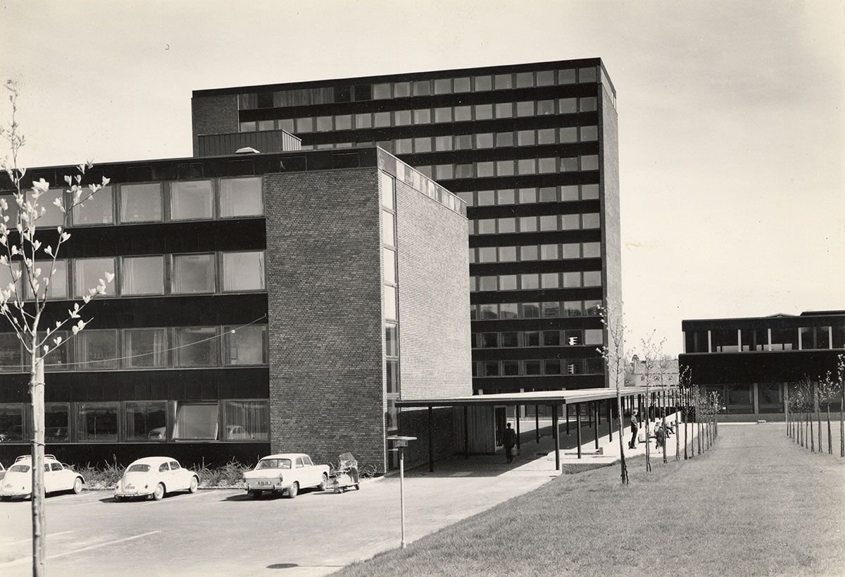 Her ser vi HF-komplekset fra Problemveien. Lengst mot oss ligger Wergelands hus. Til høyre ligger Sophus Bugges hus. Den høye bygningen er Niels Treschows hus. Til høyre, skjult bak de andre bygningene, ligger P. A. Munchs hus. Vi beveger oss rundt bygningene. Målet er forplassen og&amp;#160;fasaden til Niels Treschows hus, anleggets egentlige forside.
1963-1965. Fotograf: Teigens fotoatelier.&amp;#160;