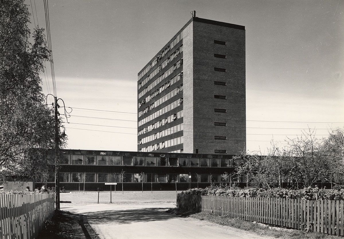 Mens den røde teglveggen til Niels Treschows hus dominerer mot nord, er det de svarte platene mellom vindusbåndene som preger&amp;#160;de øvrige bygningsfasadene. Dette er såkalte robinsonplater, rillede stålplater belagt med et tynt lag av svart asfalt.&amp;#160;
1963-1965. Fotograf: Teigens fotoatelier.&amp;#160;