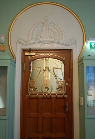 Dør fra Mynkabinettet inn til kontorene. Gitteret har jugendornamentikk inspirert av norrøne former og sannsynligvis museets egne arkeologiske samlinger.