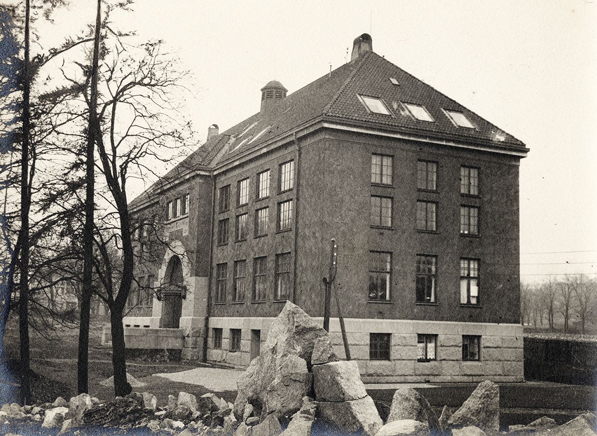 Sinding-Larsen har gitt Botanisk museum en noe annerledes utforming enn de to andre museene. Det ligger også for seg selv, inne i den opprinnelige Botanisk hage og nær veksthusene og Tøyen hovedgård. Botanisk museum stod ferdig i 1913. Det har slemmet puss, påført med sirkelformede bevegelser. Inngangspartiet har en kraftig svingdør, slik som i Sinding-Larsens samtidige Universitetsbibliotek på Solli. Som i biblioteket ledes publikum inn i en flott og høyloftet, hvelvet vestibyle.
Foto: Ukjent/MUV. Udatert.