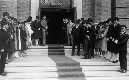 Åpningsdagen for Statens Tannlegeinstitutts nye bygning 27. mai 1927. Studenter og festkledde herrer venter ved den røde løperen.